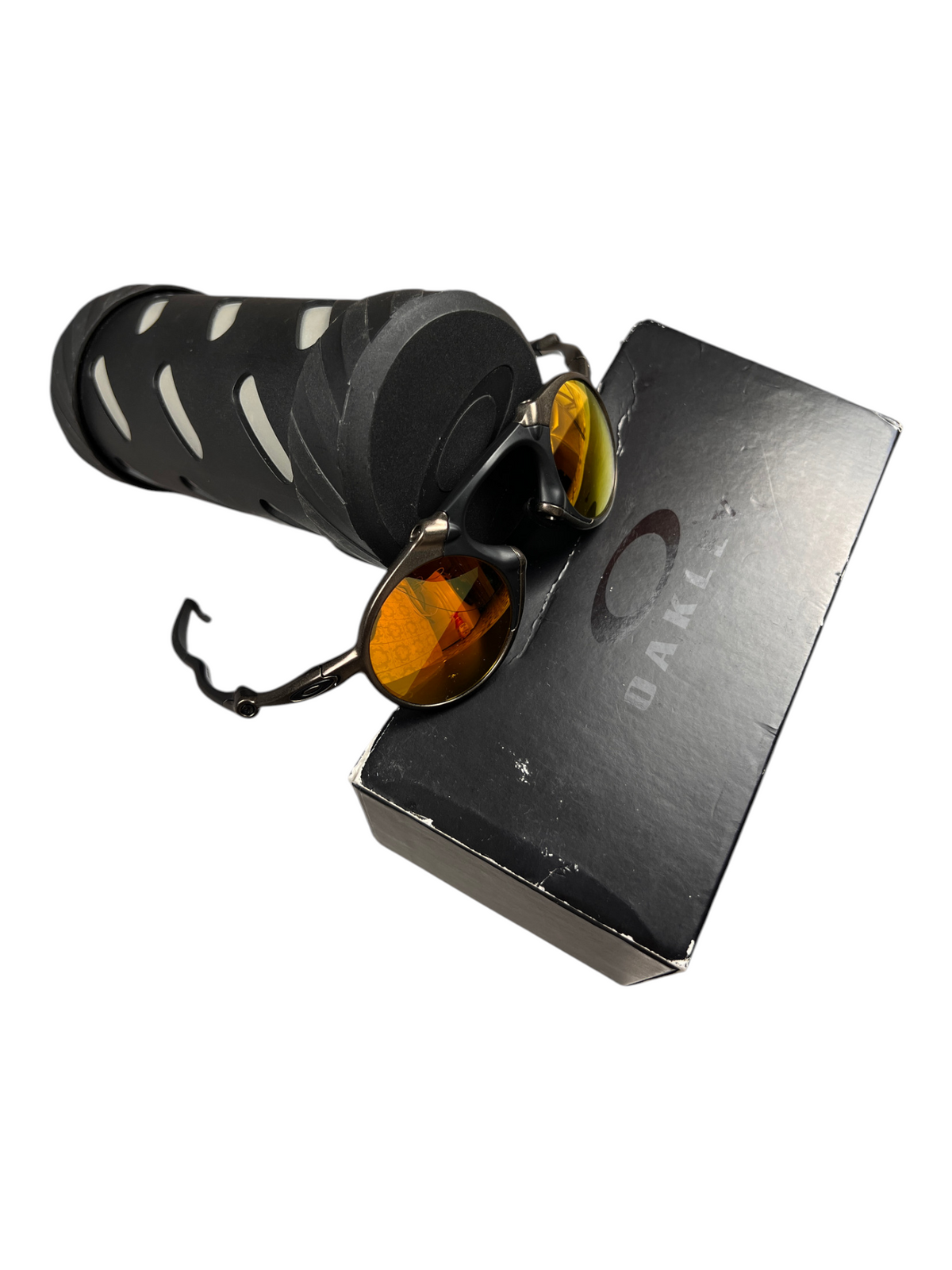 Oakley Madman Fire Iridium on top of the cylinder vault beside its box