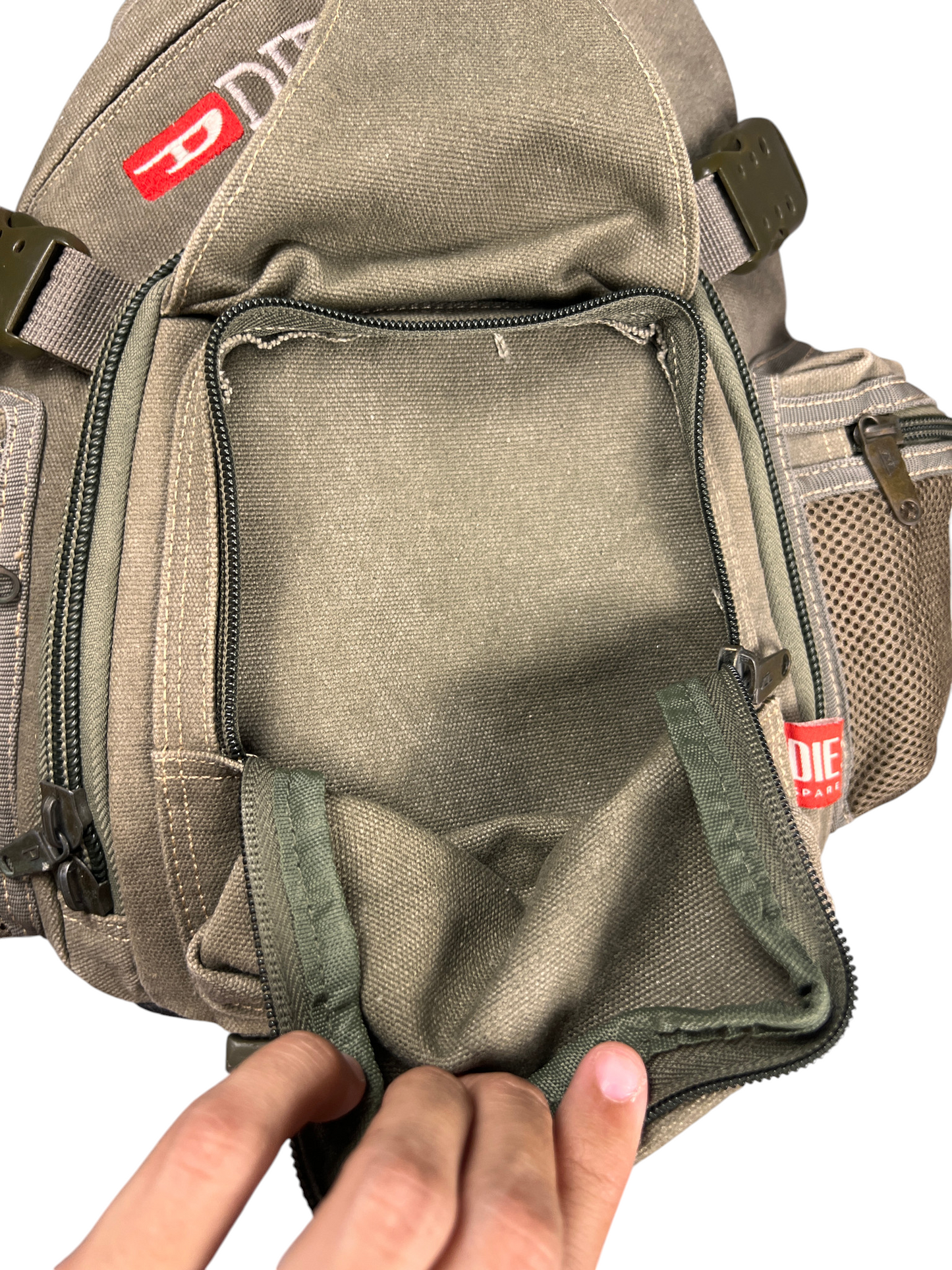 Hand opening the flap pocket of the vintage Diesel sling bag